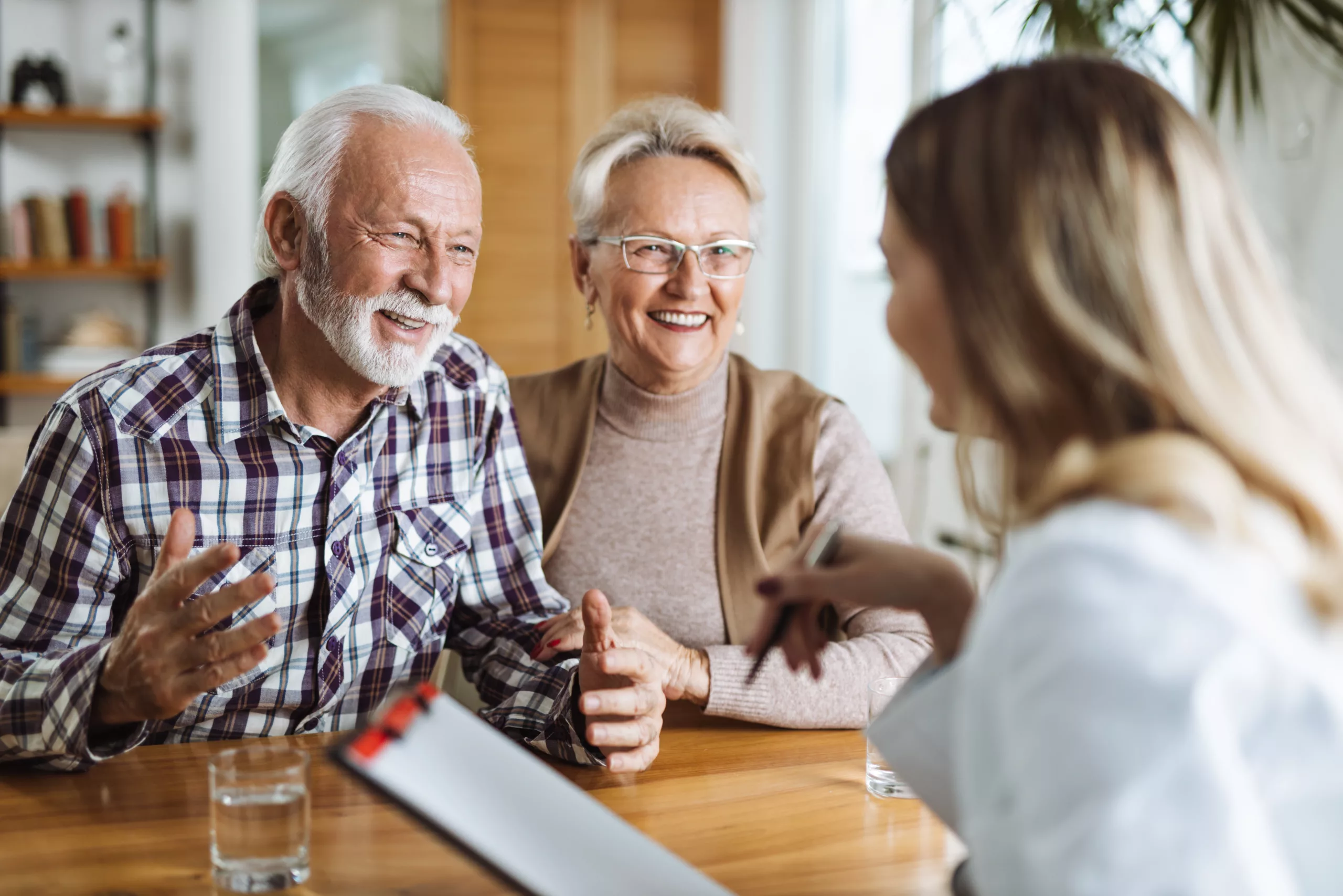 Older couple seated at desk talking to a professional woman